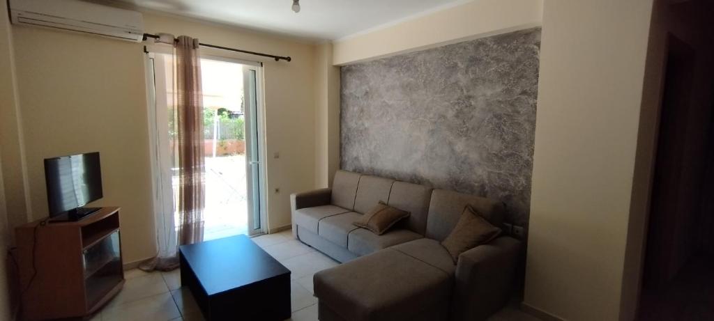 ein Wohnzimmer mit einem Sofa und einem TV in der Unterkunft Green House Messini in Messini