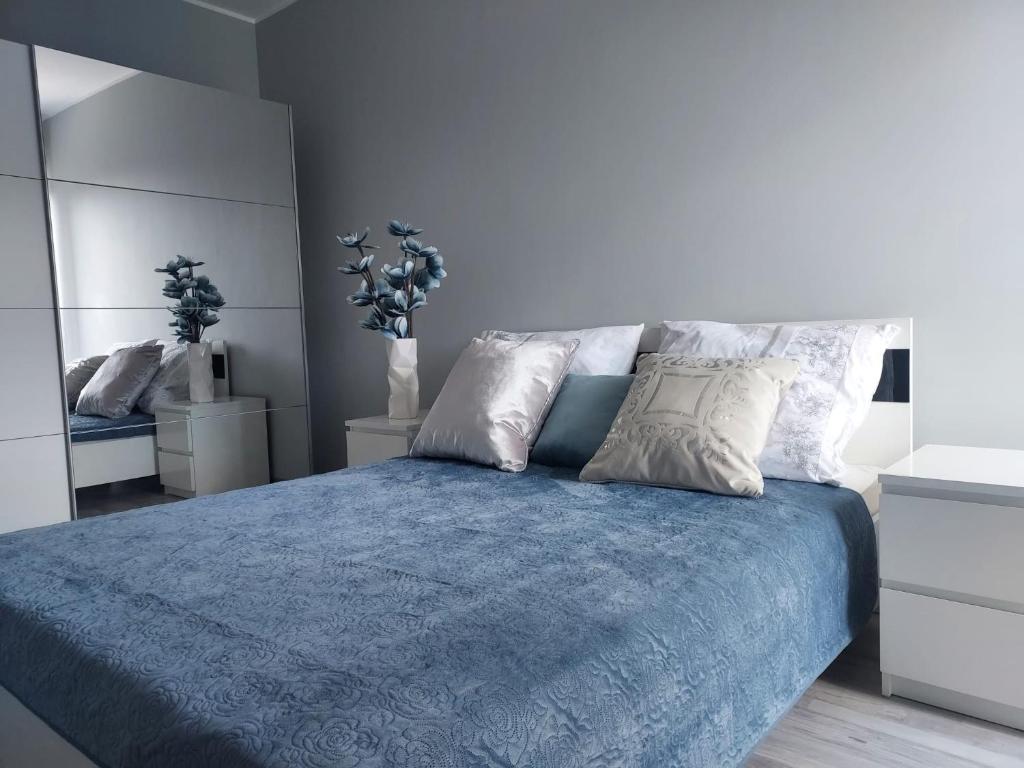 1 dormitorio con cama azul y almohadas blancas en Modern Apartment - Francuska Park en Katowice