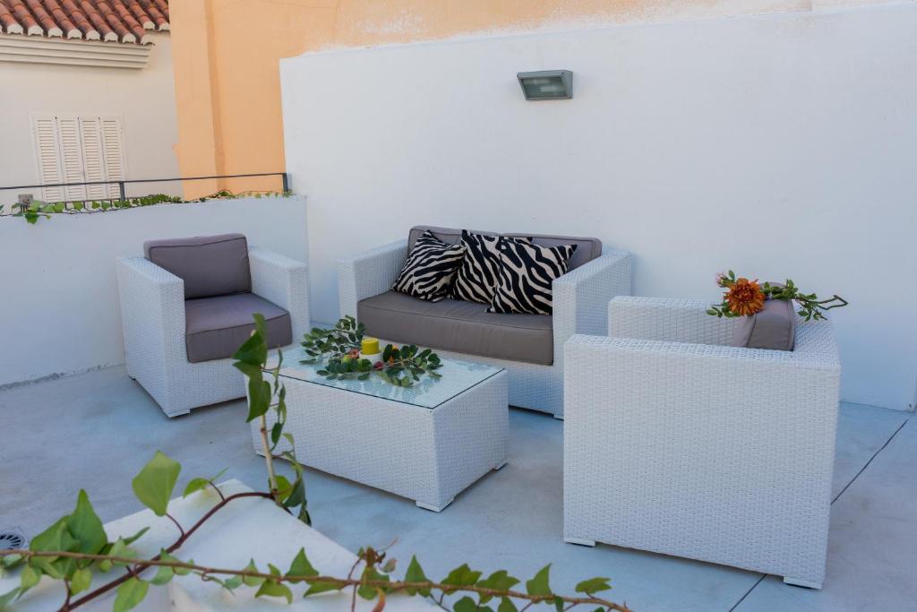 un patio con 2 sillas, un sofá y una mesa en AB Apartamentos Museum, en Málaga