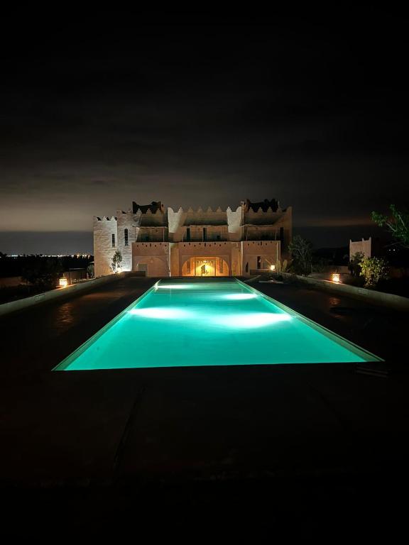 a large swimming pool in front of a building at night at Riad Nohad Marrakech Villa Privatisée in Oulad Boudene