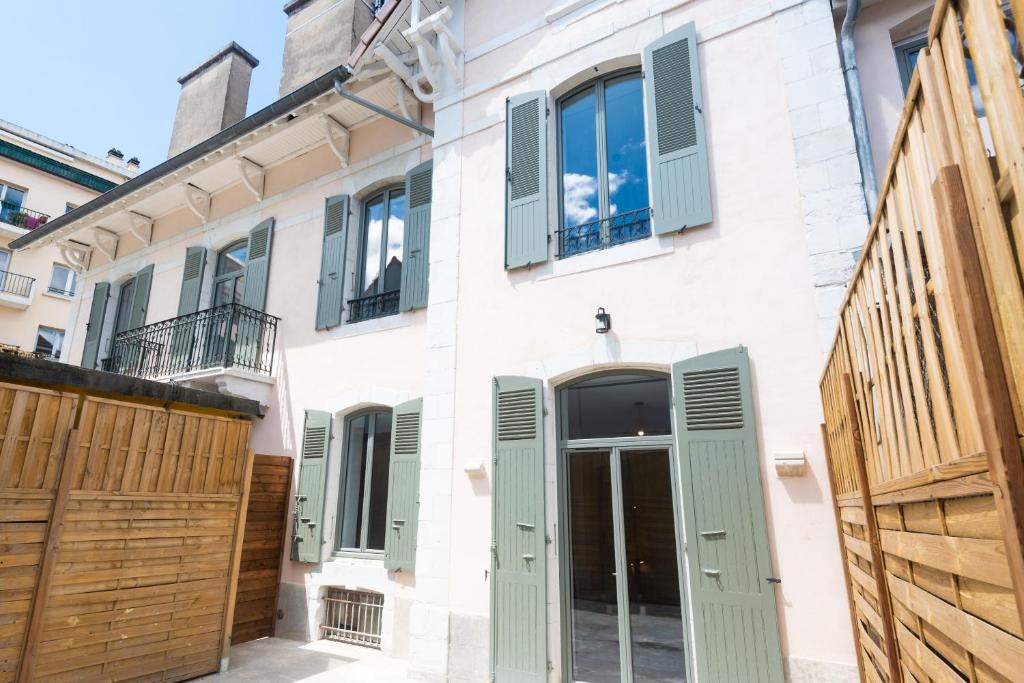una casa con puertas verdes y una valla en Appartements centre-ville - Wifi - Cuisine tout équipée - Lave-linge en Pau