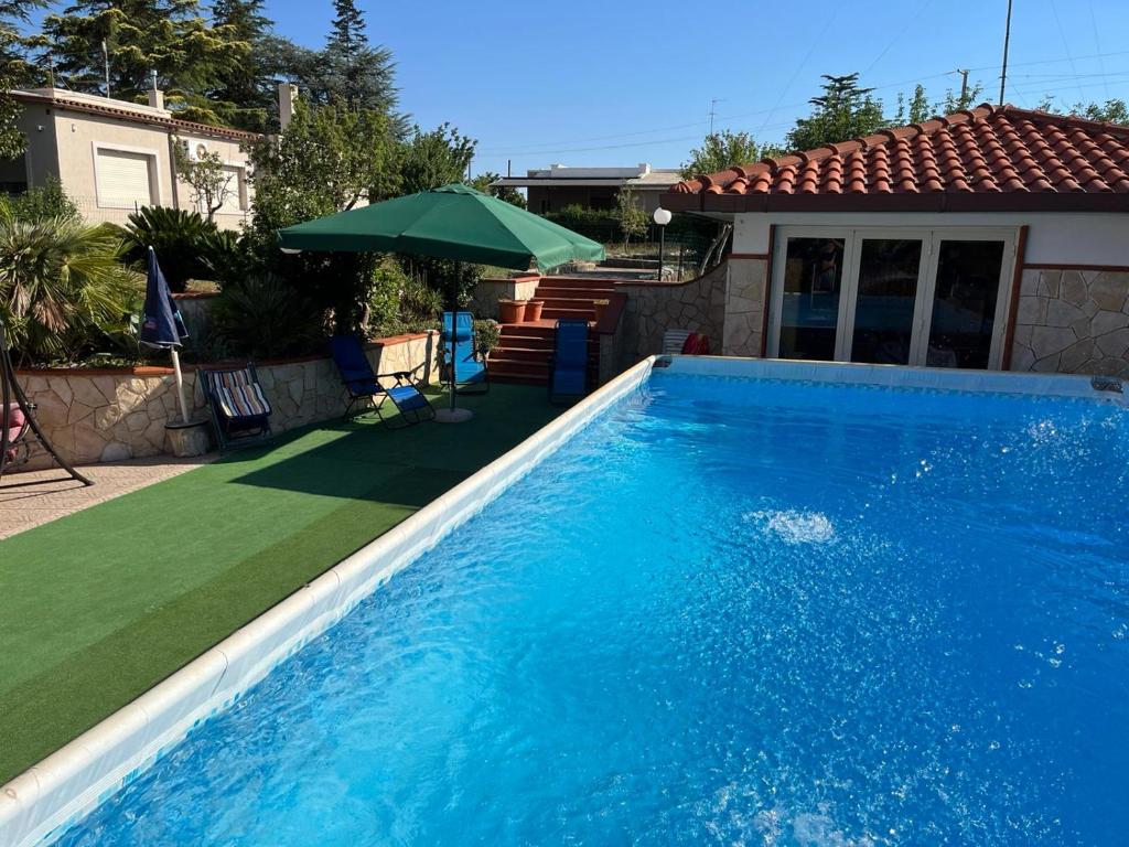 - une grande piscine bleue dans une cour avec une maison dans l'établissement Emyhouse54, à Martina Franca