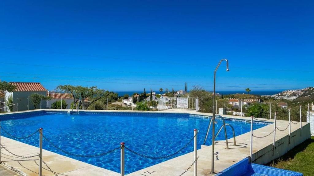 uma grande piscina azul com o oceano ao fundo em Garden Apartment, La Noria em Málaga