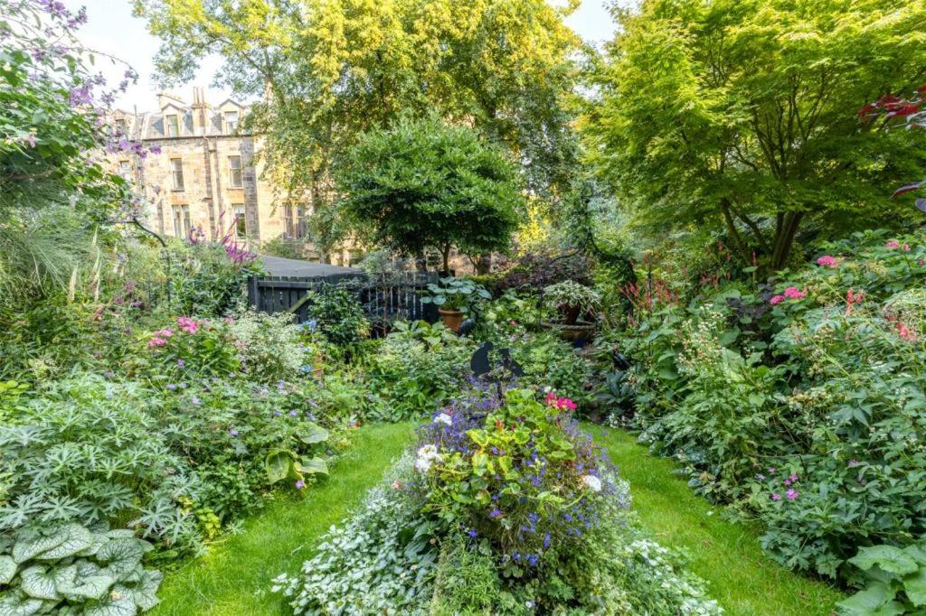 un jardín con flores y un edificio de fondo en Beautiful Double Room in Idyllic West End Townhouse, en Glasgow