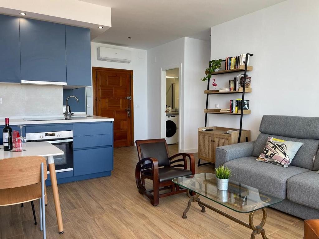 a kitchen and a living room with a couch and a table at La Roca Sea View Apartment in Torremolinos