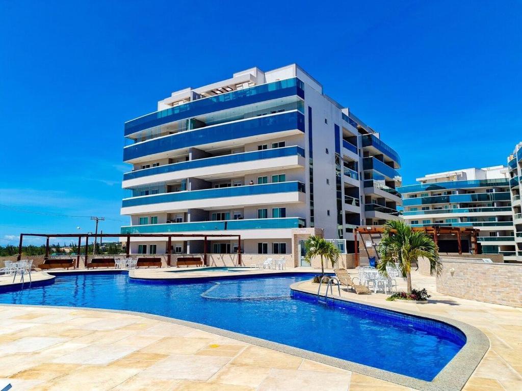 a large building with a swimming pool in front of a building at Arraial do Cabo. Conforto, Piscina, Vista Mar. in Arraial do Cabo