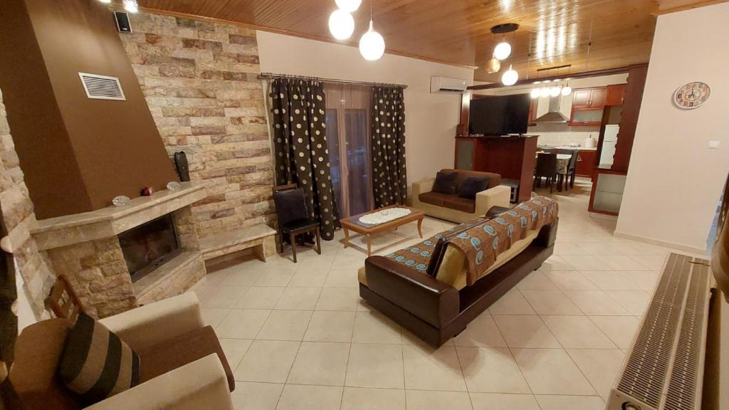 een woonkamer met een bank en een open haard bij WoodHouse in Markopoulon