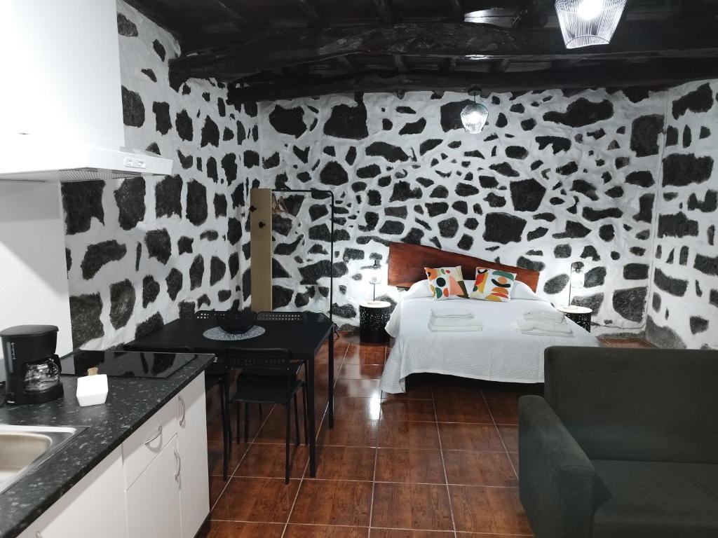 sypialnia z łóżkiem w kamiennej ścianie w obiekcie MAGMA RRAL3529 w mieście Velas