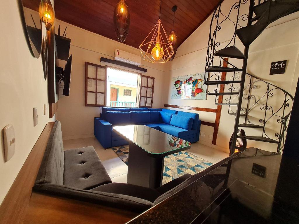 a living room with a blue couch and a staircase at Apto Duplex, Peró - Cabo Frio. Conforto, Piscina, Beira Mar. in Cabo Frio
