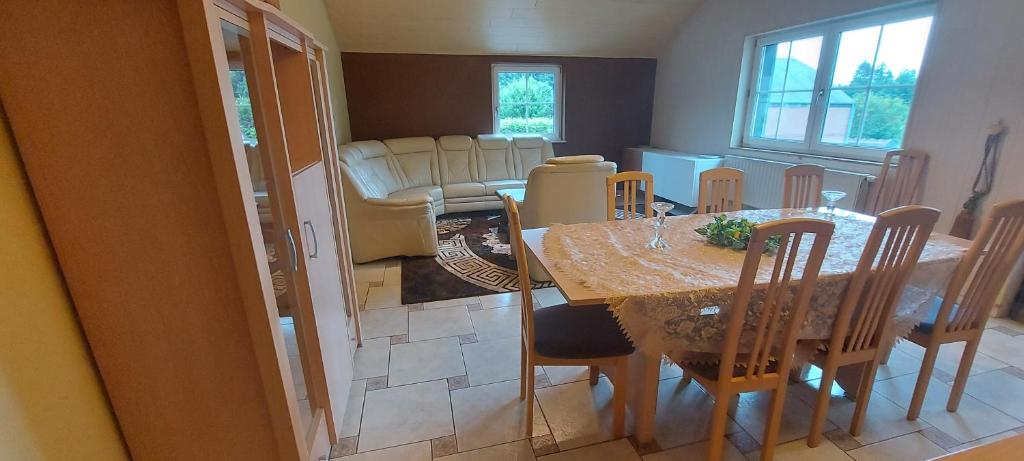 uma sala de jantar e sala de estar com mesa e cadeiras em Nazareth logement em Bastogne