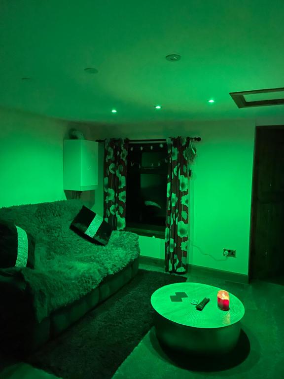 a green room with a bed and a table at Cabin with Hot Tub in Aberdeenshire in Gamrie