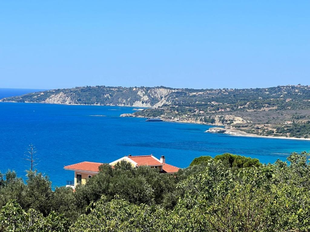 una casa su una collina vicino a un corpo d'acqua di Aristomenis Studios a Vlachata