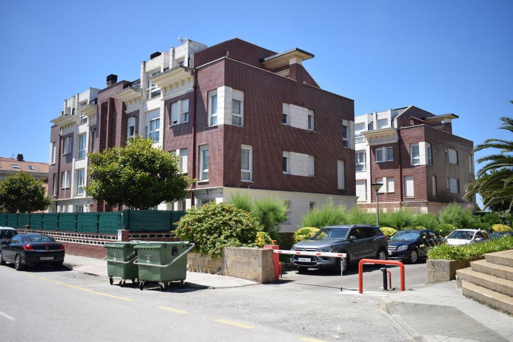 ein Gebäude mit Autos auf einem Parkplatz in der Unterkunft Apartamentos Somo1 in Somo