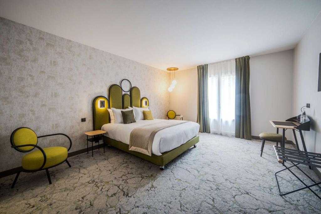 - une chambre avec un grand lit et une grande tête de lit dans l'établissement Best Western Le Relais du Vigneron, à Vertus