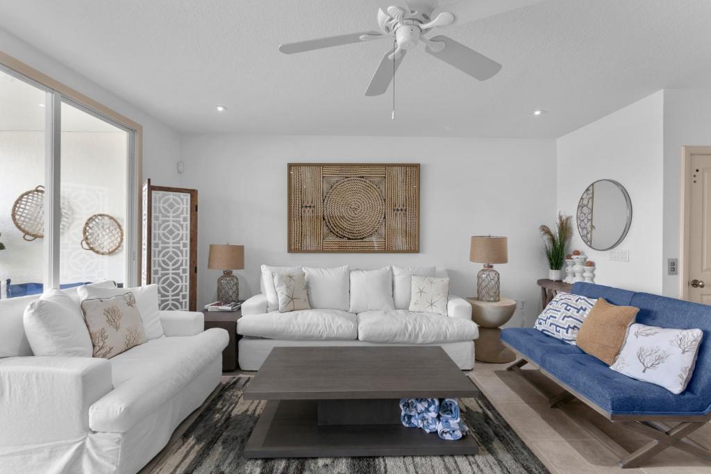 a living room with a white couch and a ceiling fan at Bradenton Beach Club #13 in Bradenton Beach