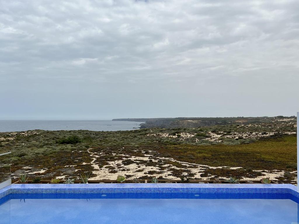 a swimming pool with a view of the beach at Alojamento White Rose Boutique in Zambujeira do Mar