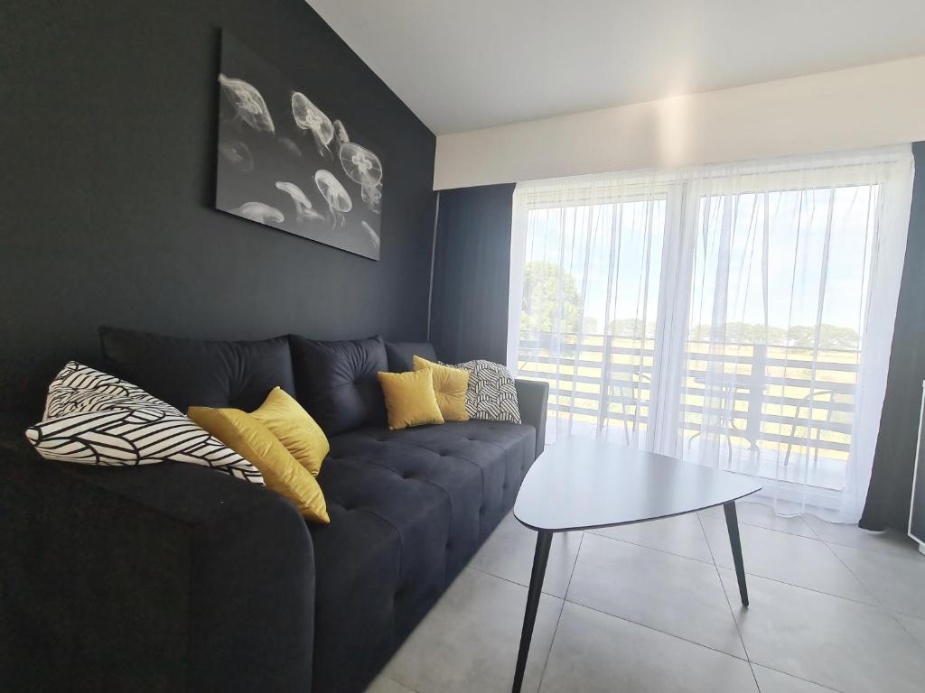 un soggiorno con divano blu e tavolo di Apartamenty Morze u Sary a Dziwnówek