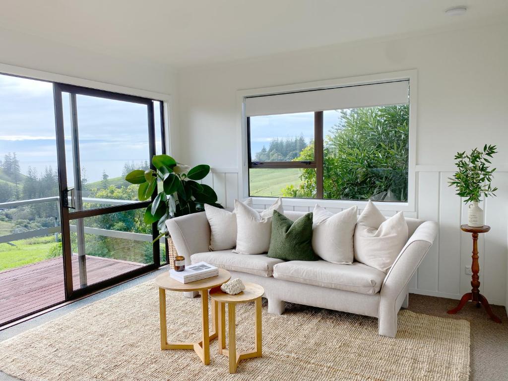 sala de estar con sofá blanco y ventana grande en The Ridge, en Burnt Pine