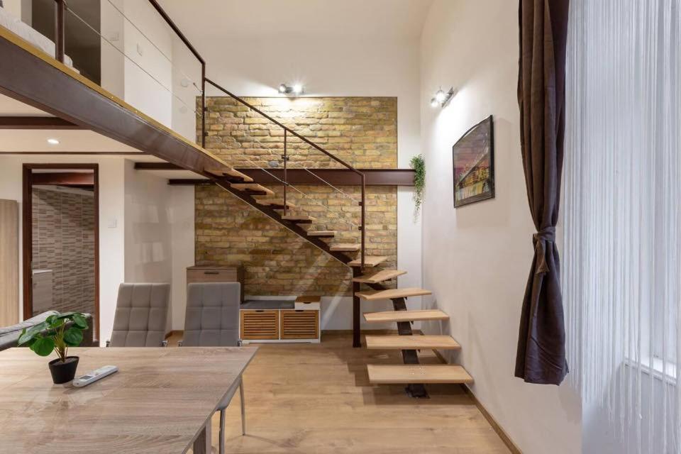 a staircase in a house with a brick wall at Stylish loft flat in the heart of Budapest in Budapest