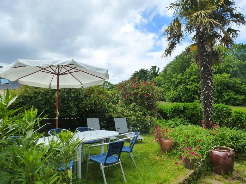 - une table et des chaises sous un parasol dans le jardin dans l'établissement Holiday Home in Perros-Guirec near Beaches, à Perros-Guirec