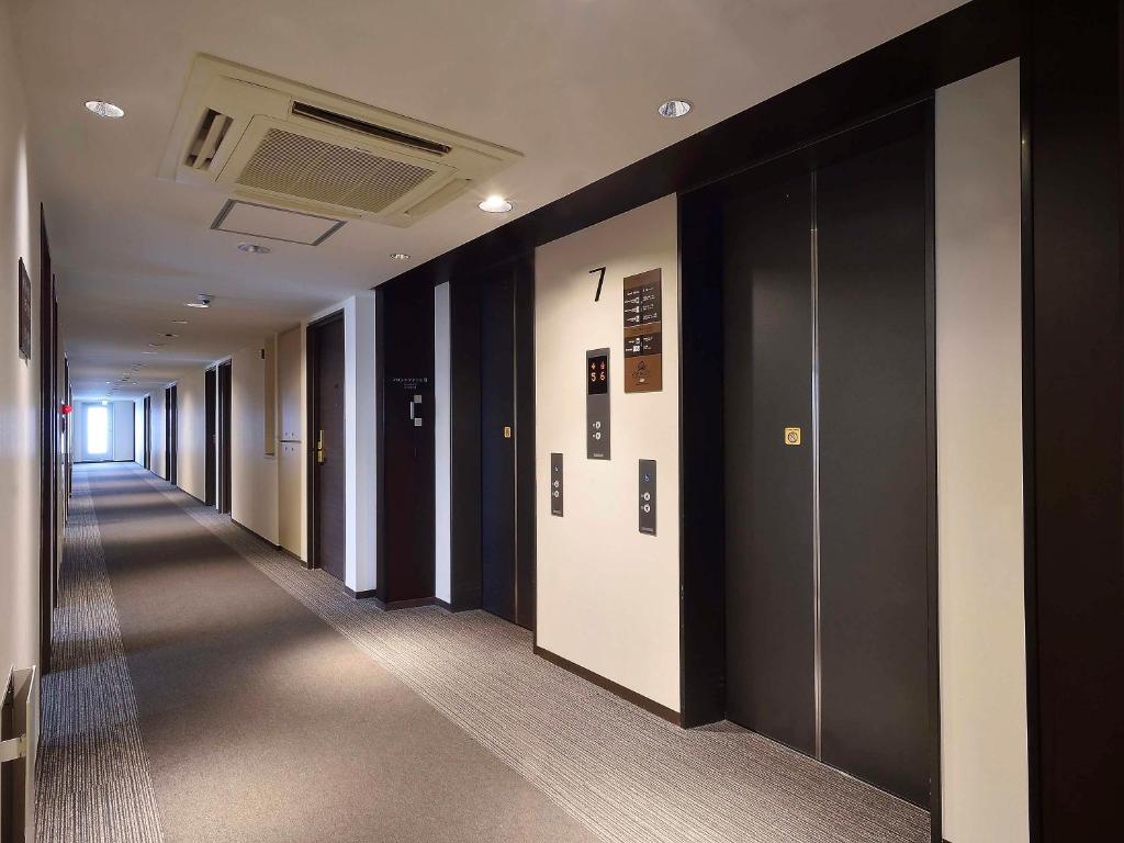 a hallway of an office building with black and white walls at APA Hotel Haneda Anamori Inari Ekimae in Tokyo