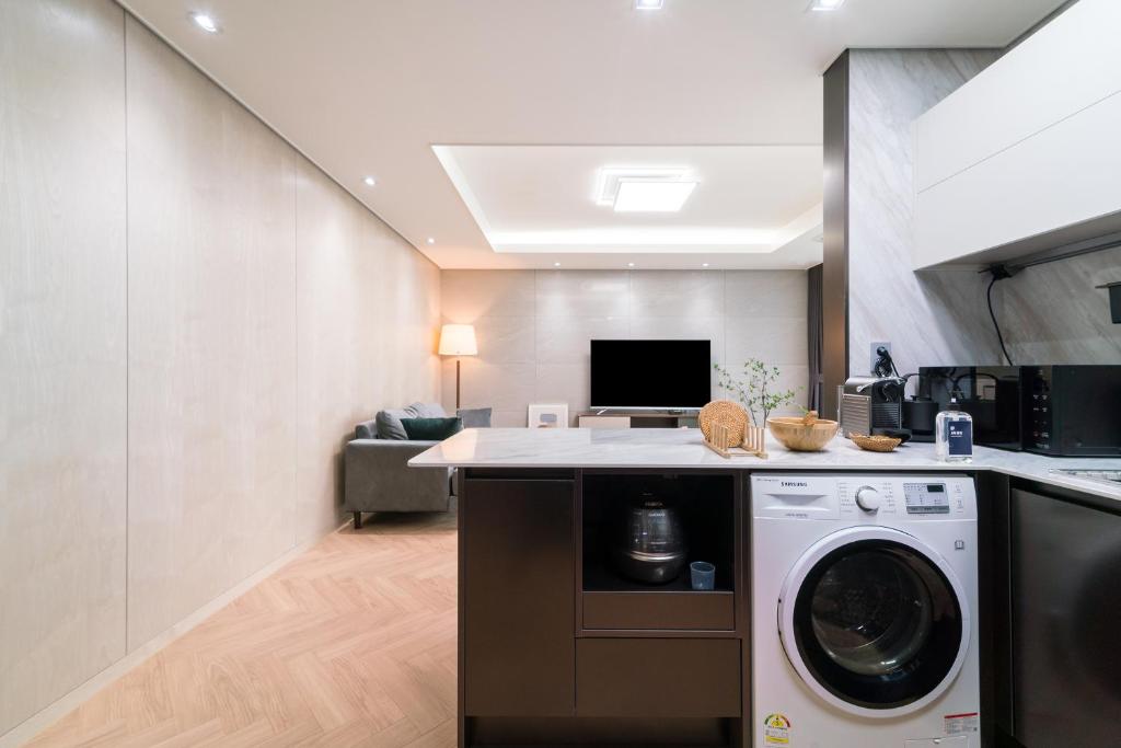 a kitchen and living room with a washer and dryer at Le Collective Busan station in Busan