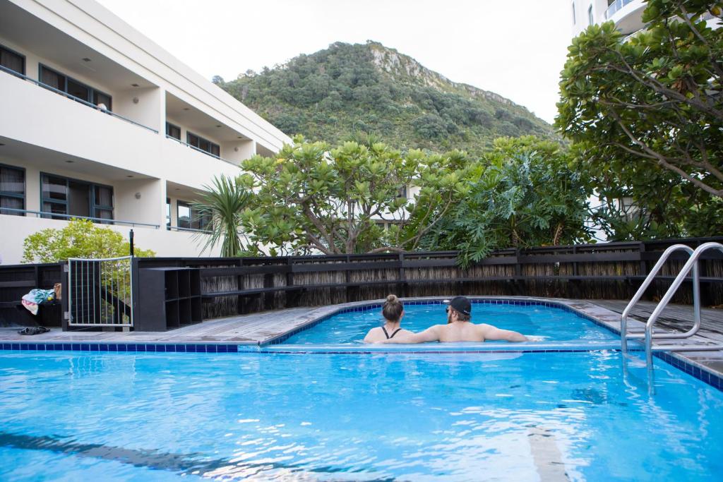 - deux personnes dans la piscine d'un hôtel dans l'établissement Ocean Retreat 222, à Mount Maunganui