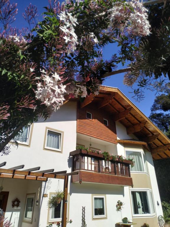 a large white building with a balcony at Villa Gruntal Hospedaria in Treze Tílias