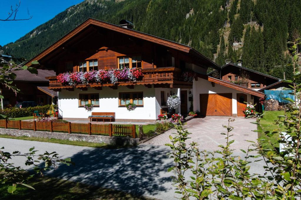 a house in the mountains with flowers in the windows at Ferienwohnung Maria Erlsbacher in Sankt Veit in Defereggen