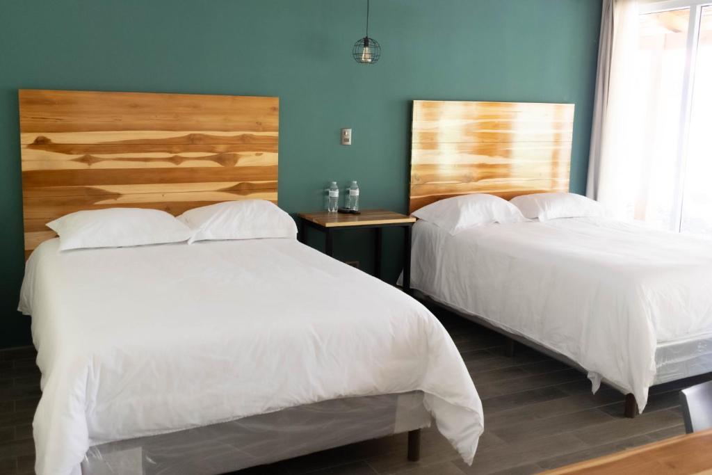 チチカステナンゴにあるCasa Montana Hotelの青い壁のベッドルーム1室(ベッド2台付)