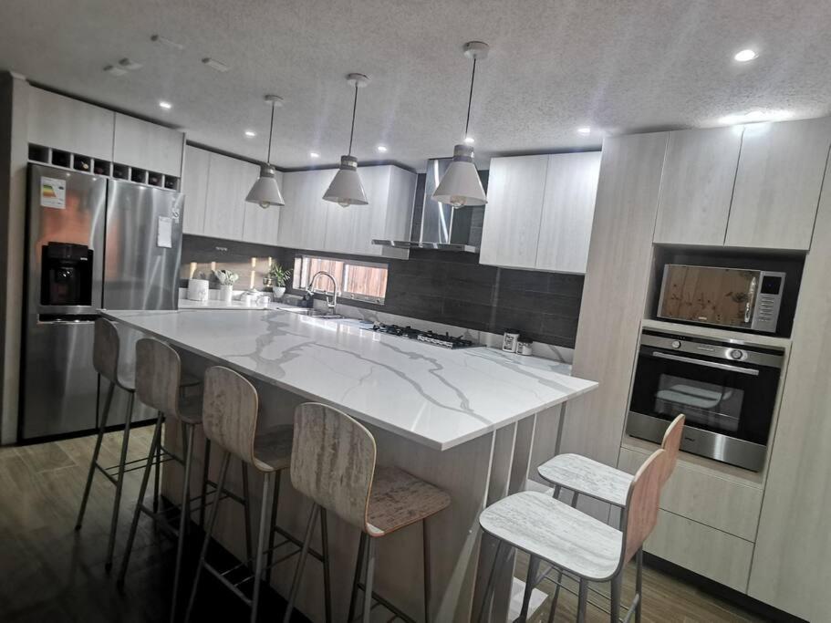 a kitchen with a large island with bar stools at Casa Especial in Puerto Natales