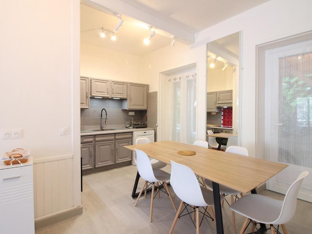 - une cuisine avec une table en bois et des chaises blanches dans l'établissement Maison La Bourboule, 6 pièces, 8 personnes - FR-1-608-230, à La Bourboule