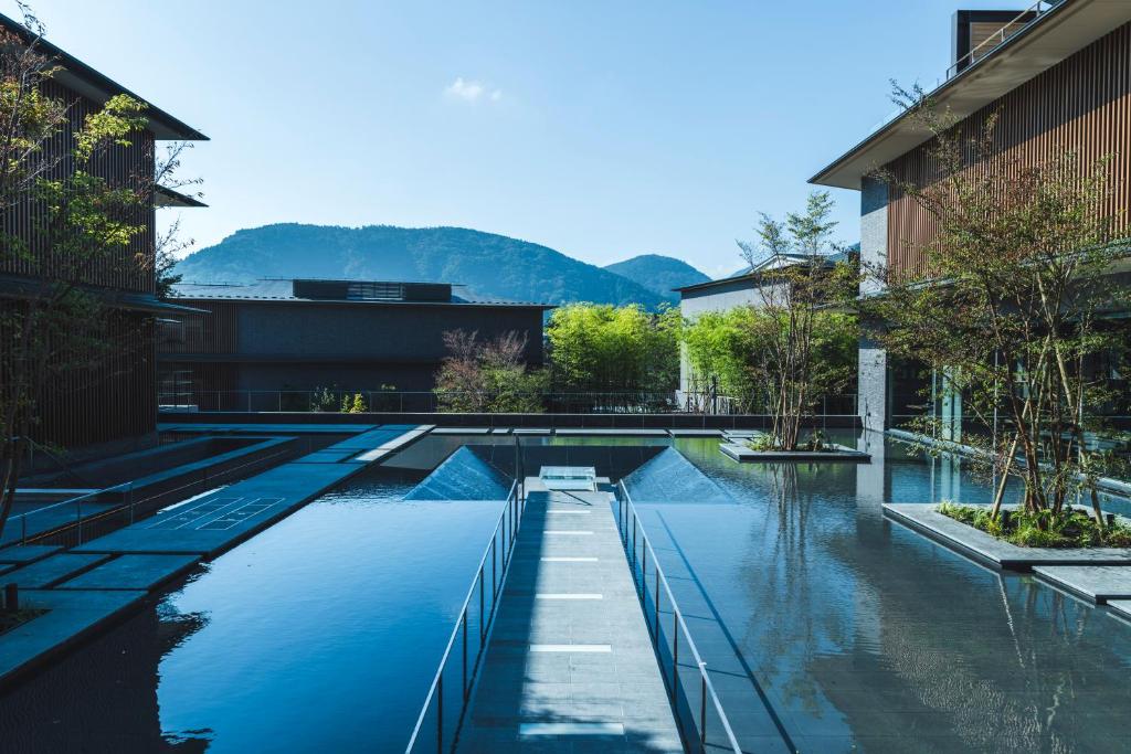 a swimming pool in a building with mountains in the background at Hakone Gora KARAKU in Hakone