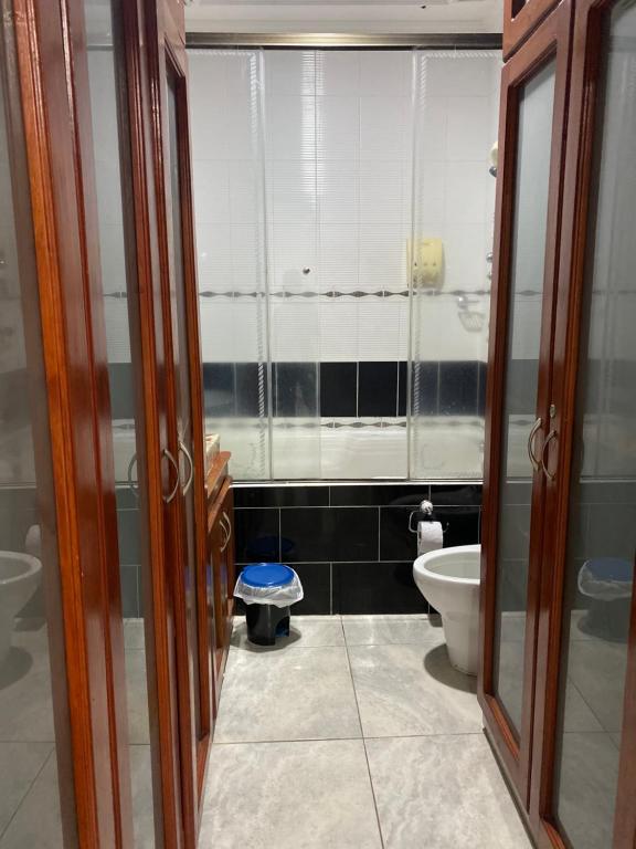 a bathroom with a toilet and two glass doors at CASA CON JACUZZI CENTRO PEREIRA in Pereira