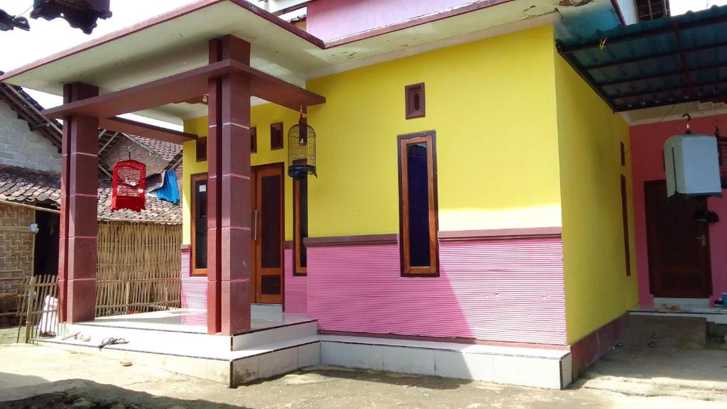 ein farbenfrohes Haus mit einer roten Tür in der Unterkunft Ijen kingdom guest house in Tamansuruh