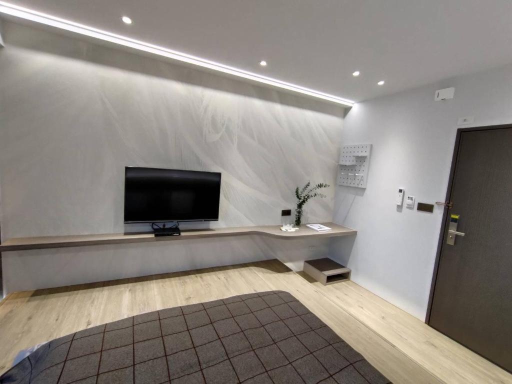 a living room with a flat screen tv on a wall at Tin Gan Beauty Hotspring in Yuanshan