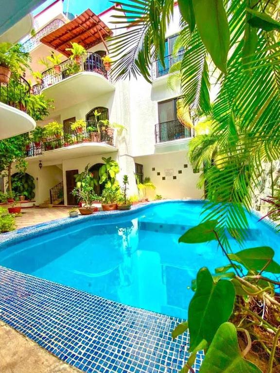 a swimming pool in front of a building at Apartment w/ PRIME location Mexican Colonial style in Playa del Carmen