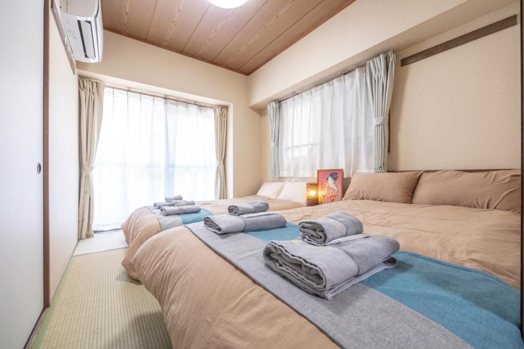 sypialnia z 2 łóżkami i dużym oknem w obiekcie nestay apartment tokyo akihabara 2A w Tokio