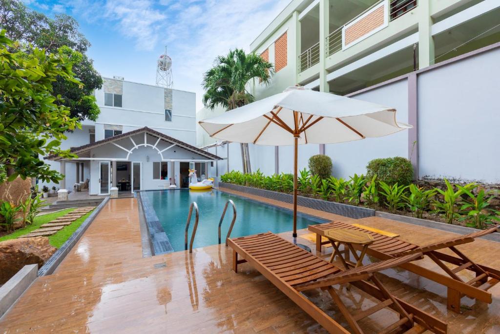 an outdoor patio with a table and an umbrella at Palm Villa 39 - Luxury Free Bida & Karaoke in Vung Tau