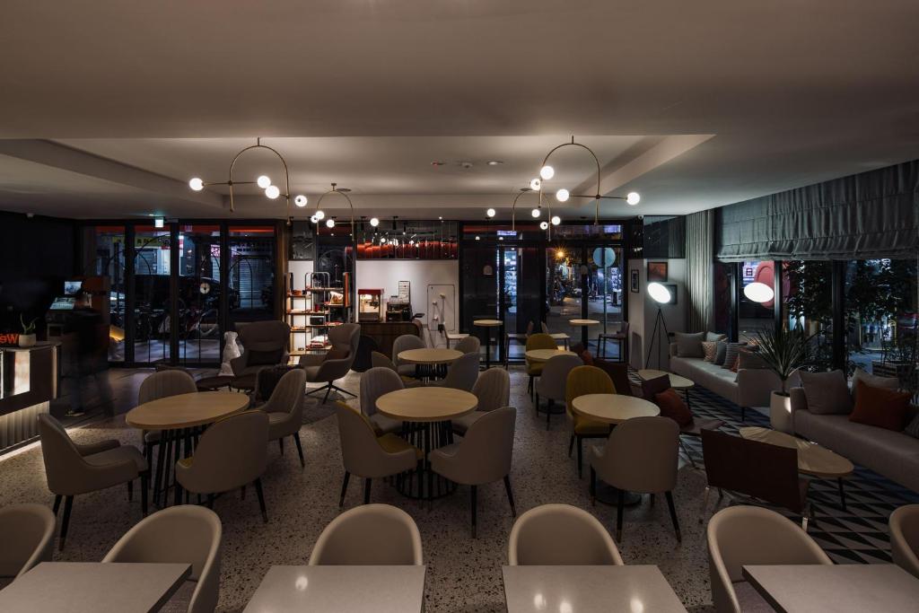 a restaurant with tables and chairs and couches at OLAH Poshtel - Taichung Station in Taichung