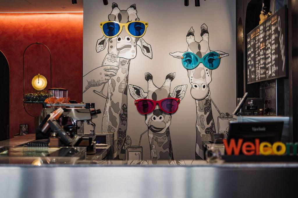 a mural of giraffes wearing sunglasses in a store at OLAH Poshtel - Taichung Station in Taichung