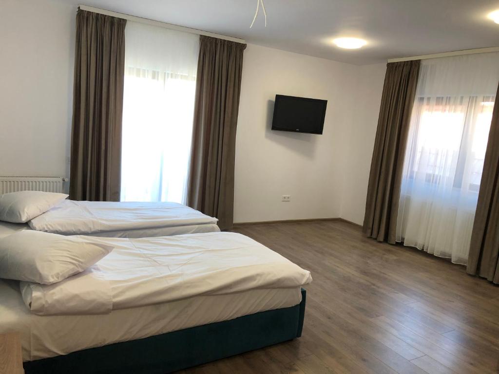 a hotel room with two beds and a flat screen tv at Aparthotel Plevnei1 in Cluj-Napoca