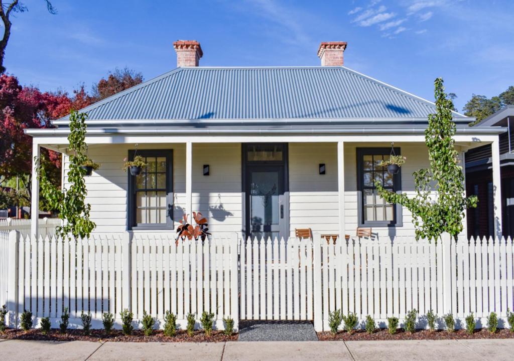 a white picket fence in front of a white house at Heritage Cottage Daylesford in Daylesford