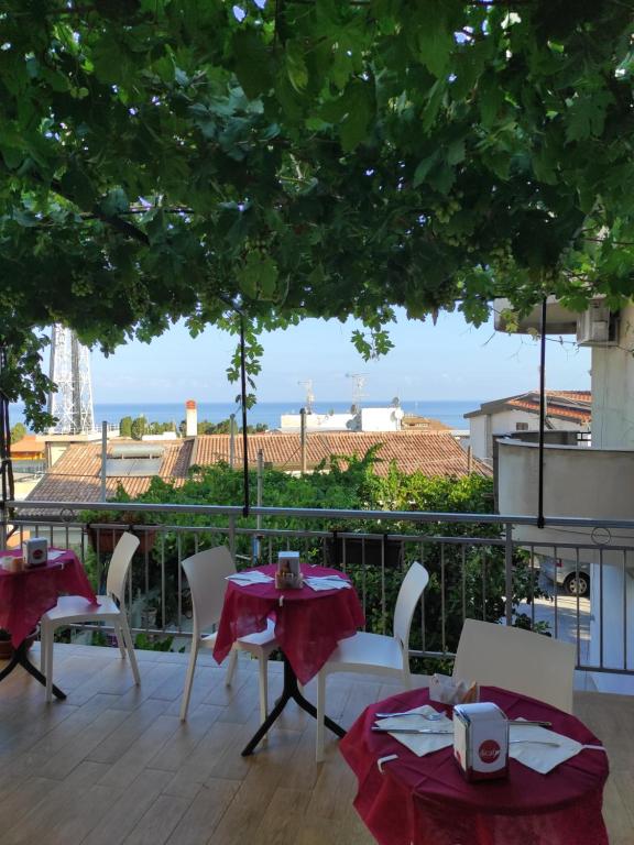 un patio con mesas y sillas y vistas al océano en B&B Leonida, en Tropea