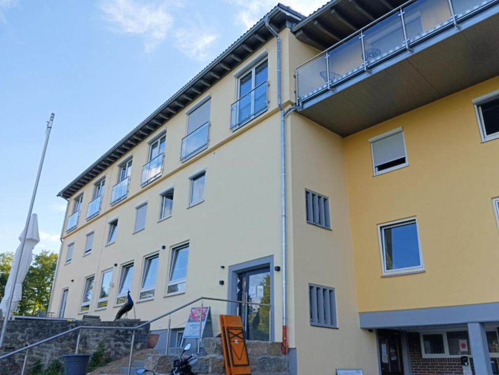 ein gelbes und weißes Gebäude mit vielen Fenstern in der Unterkunft Haus Jagstblick in Kirchberg an der Jagst