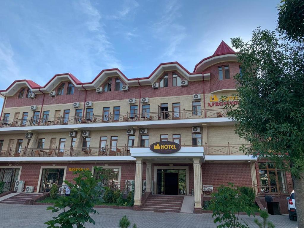 a large pink building with a mott hotel at Hotel Afrosiyob in Qarshi