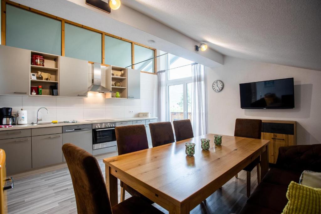 een keuken en eetkamer met een houten tafel en stoelen bij Ferienwohnung Hoamat in Reutte