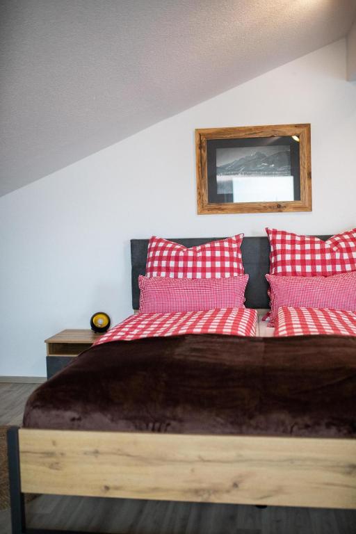 a bedroom with a bed with red and white pillows at Ferienwohnung Hoamat in Reutte