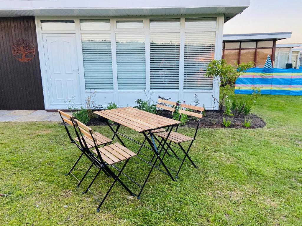 a picnic table and two chairs in a yard at 30 Granada in Selsey