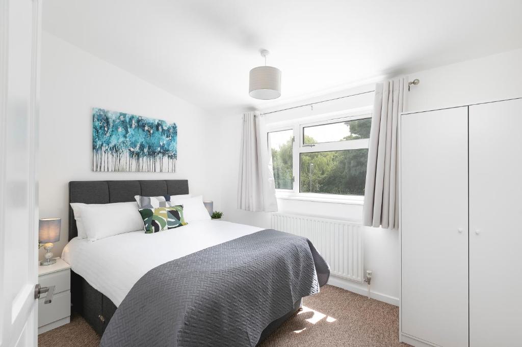 um quarto branco com uma cama e uma janela em Skyvillion - STEVENAGE SPACIOUS COMFY 2BED HOUSE with Garden, Free WiFi & Parking em Shephall